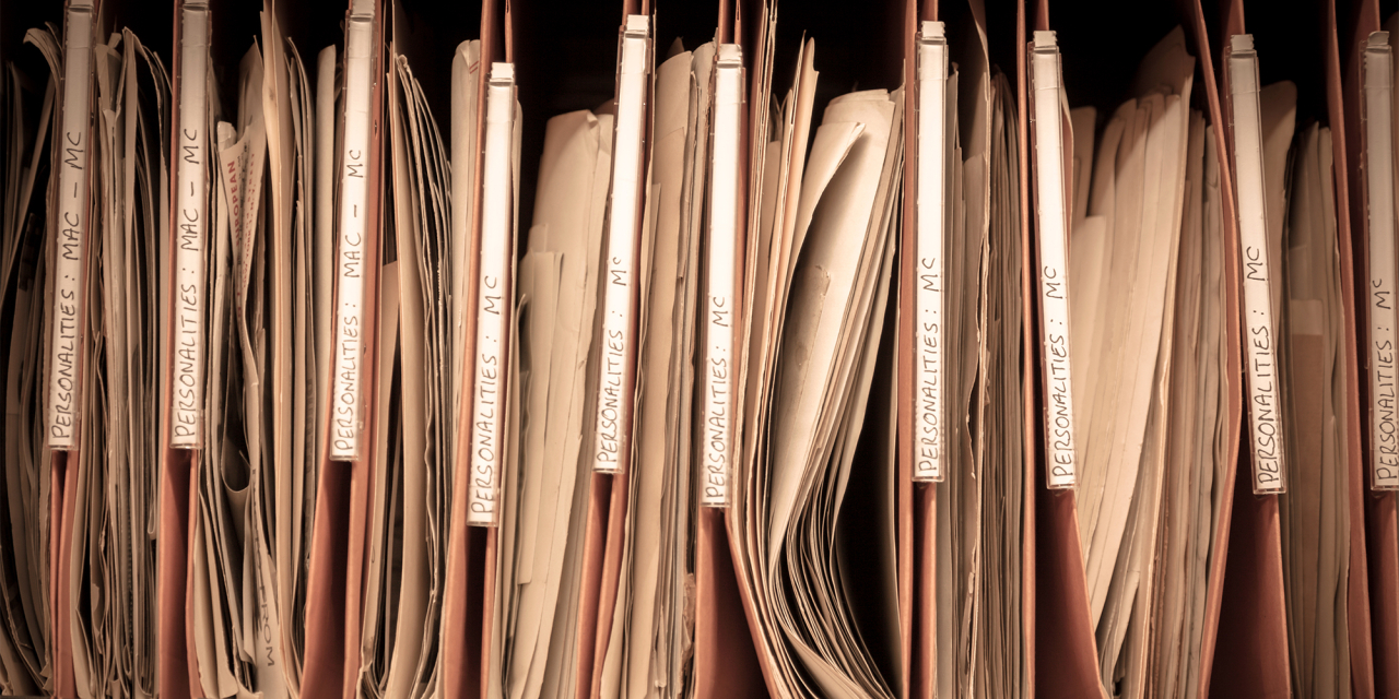 Old files hanging in a physical filing system.